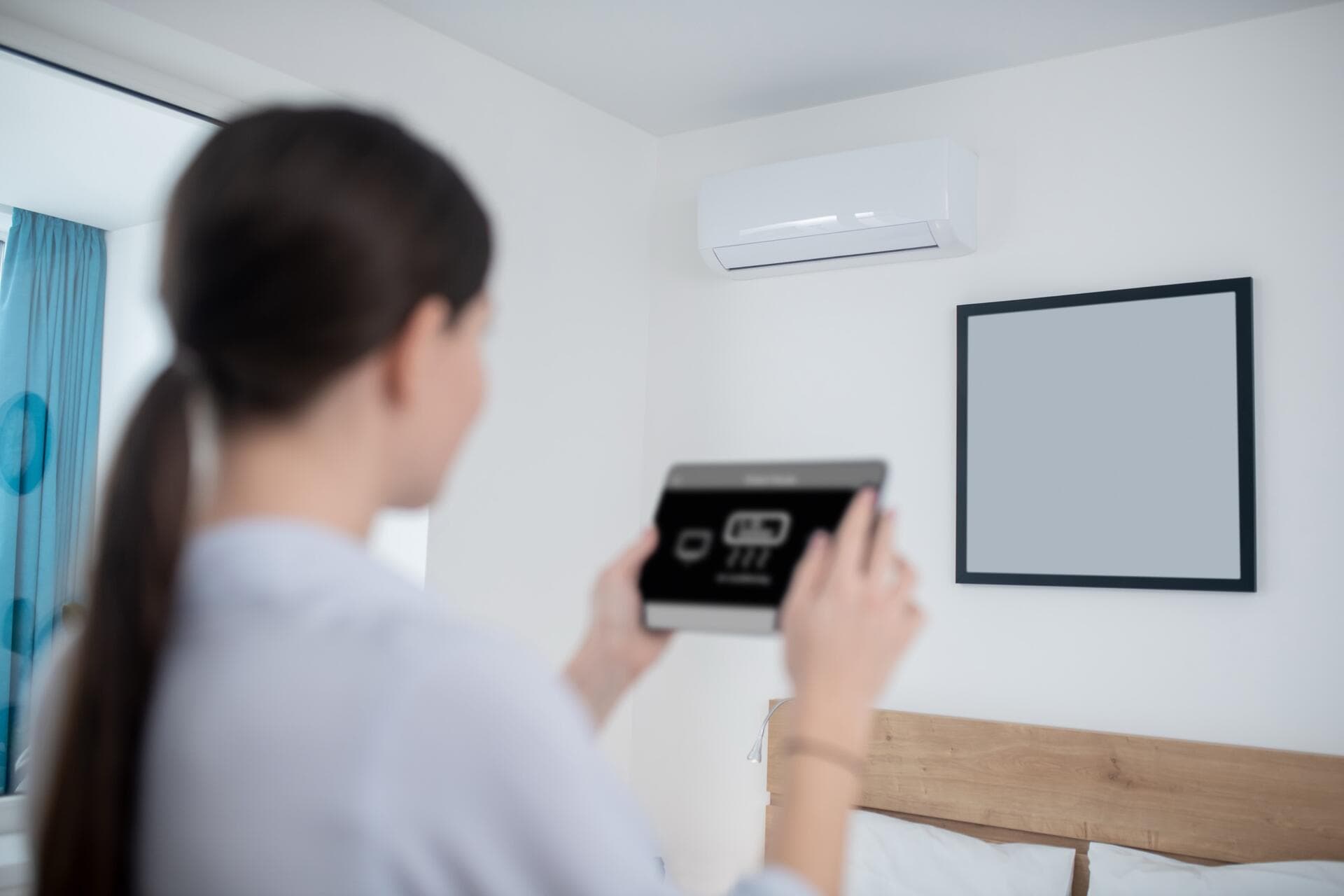 Occupante réglant depuis une tablette la pompe à chaleur air/air de sa chambre